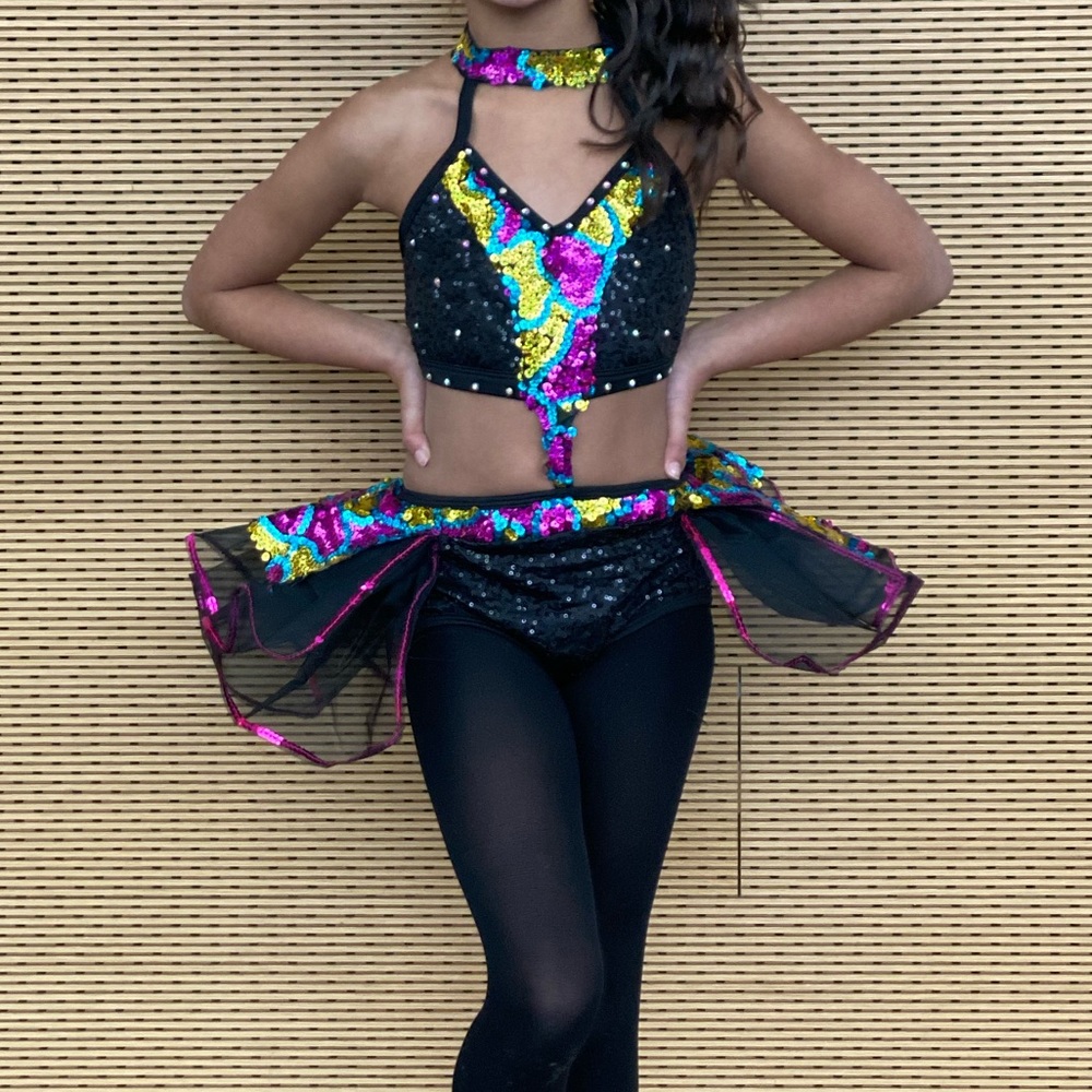 One piece black with multi colored sequins. Tutu style on back. Very cute!